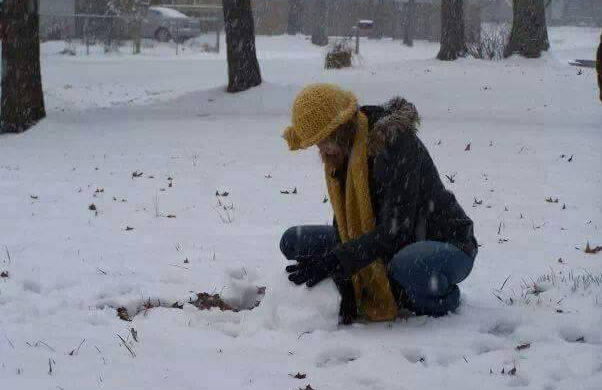 Woman sitting by a heater in winter