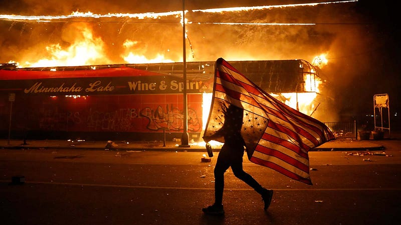 Protestor carrying an upside-down flag in Minneapolis